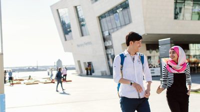 Two students laughing whilst taking a walk in the city