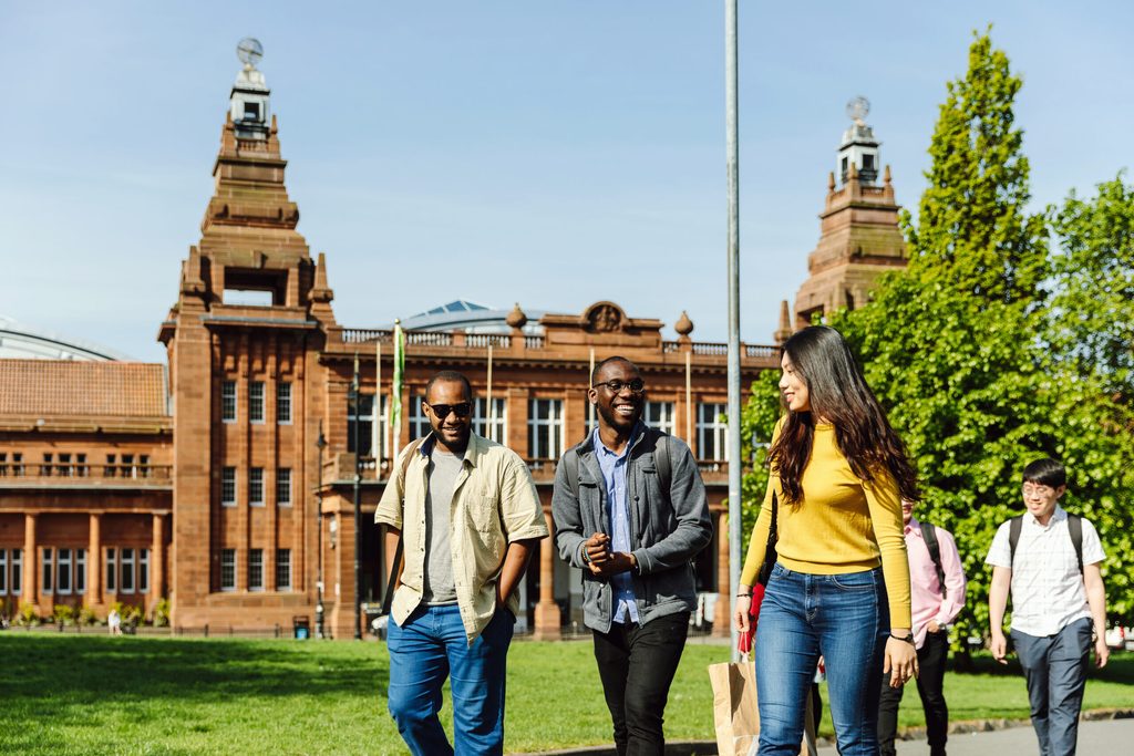 Students laughing and walking in Glasgow University campus