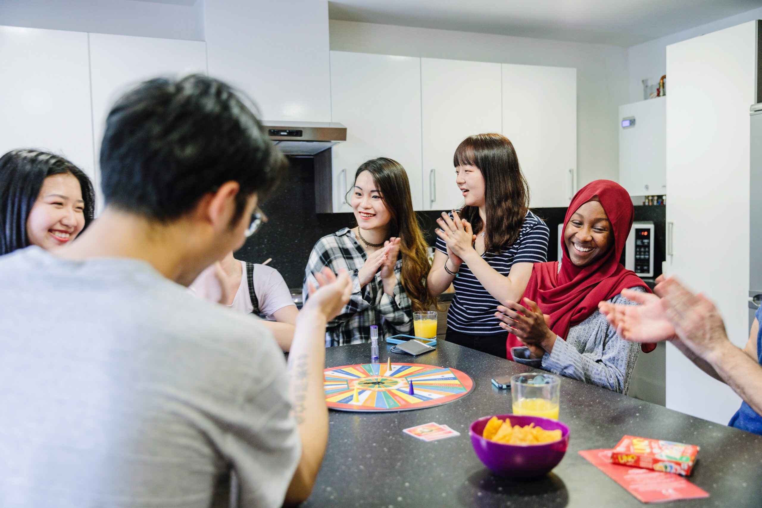 Students playing a board game in the Kaplan Living kitchen