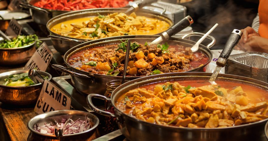 A line of warm curries and other foods