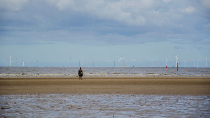 A man standing on the beach near Liverpool