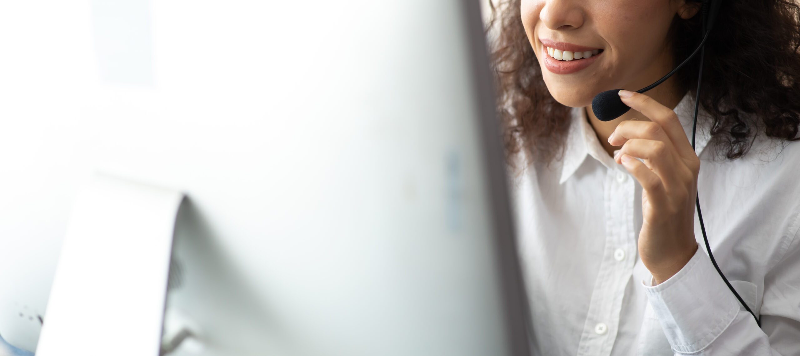 Woman in a Call with headset facing a Monitor