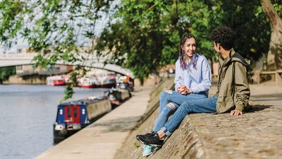 Two students chatting by the water in York