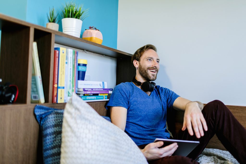 A student relaxing on a bed