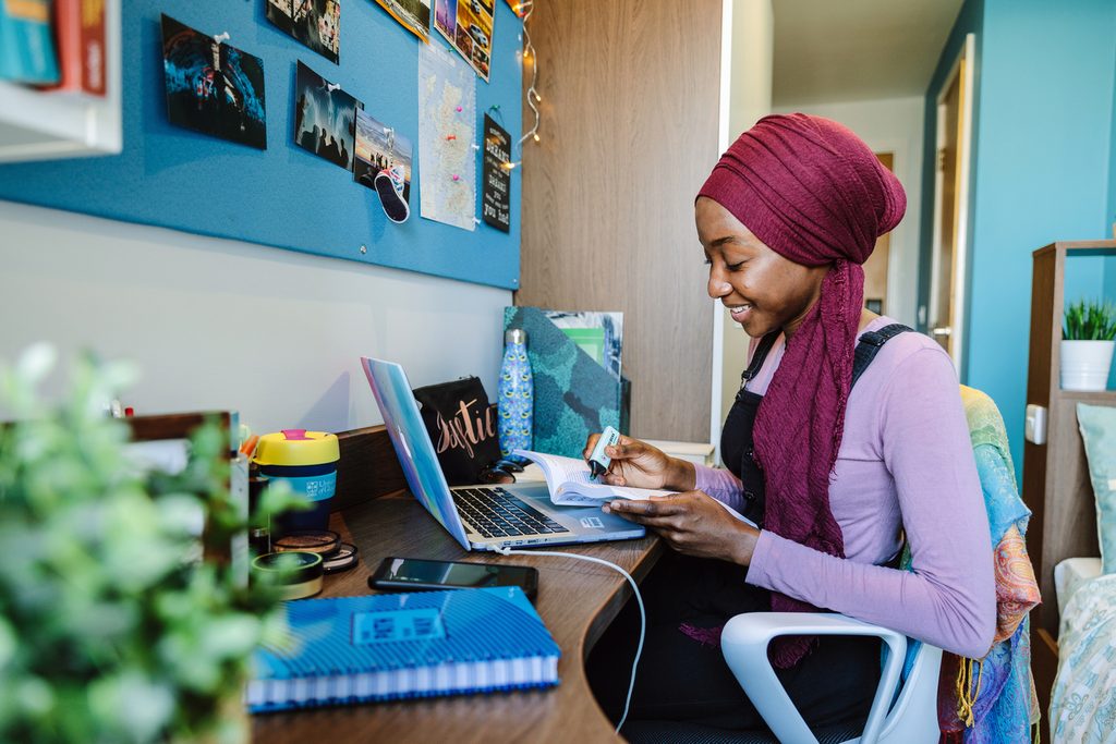A student highlighting a book sat in her room at Old Dumbarton