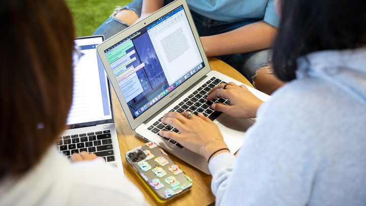 A student typing on her MacBook