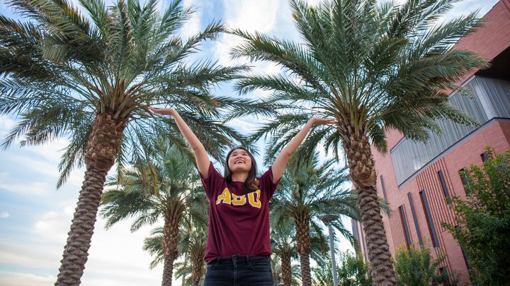 A ASU student in front of palm trees