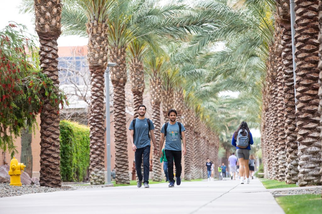 Two students walk on ASU’s Tempe campus in Palm Walk