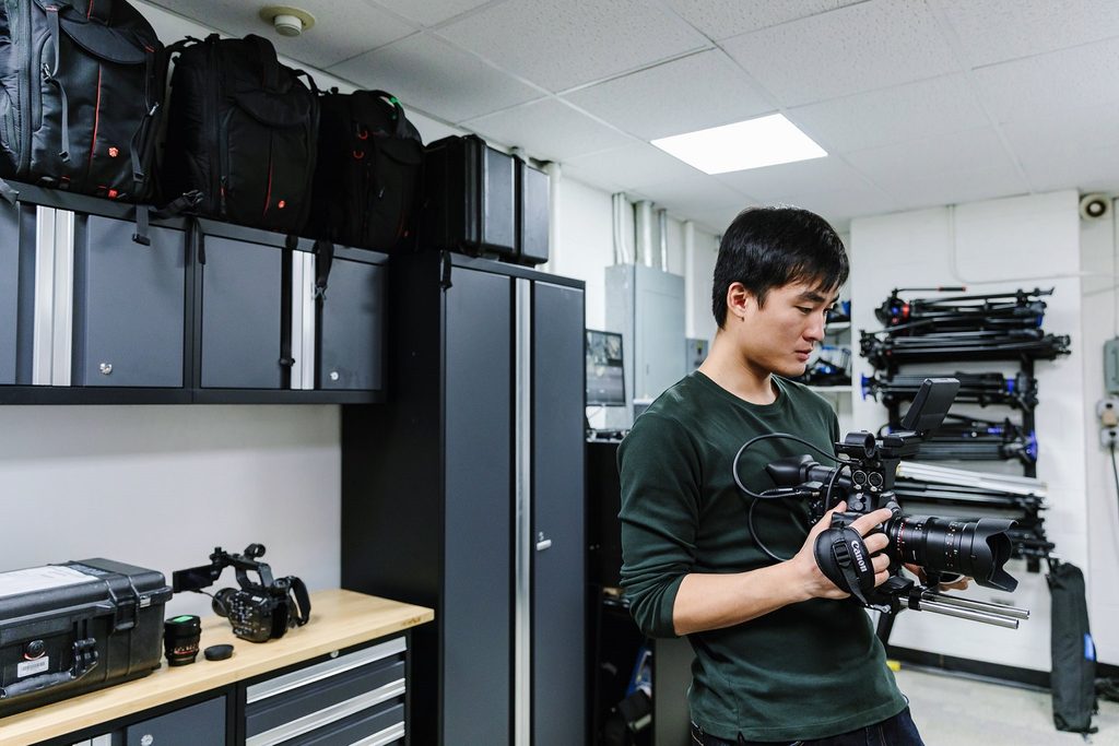 A student with a camera in a lab at Pace University