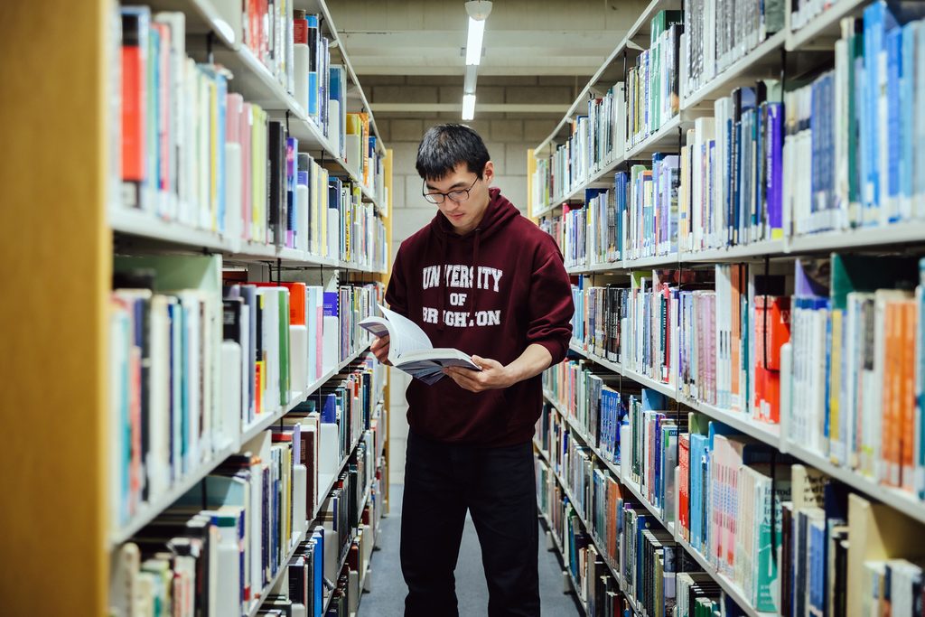 Student in library reading a book