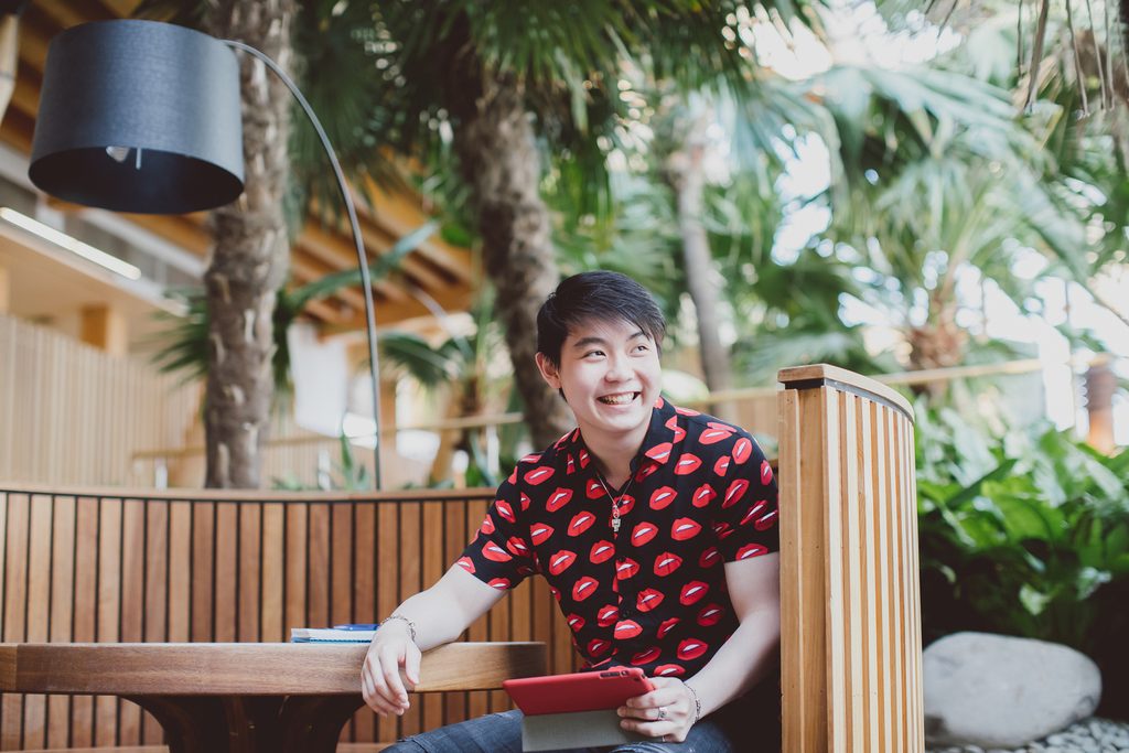 Student smiling sitted in a roundtable inside the university campus