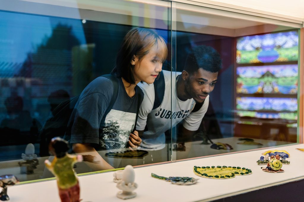 Students visiting an exhibition and looking at artwork