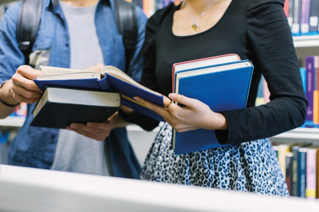 Students in library looking at books