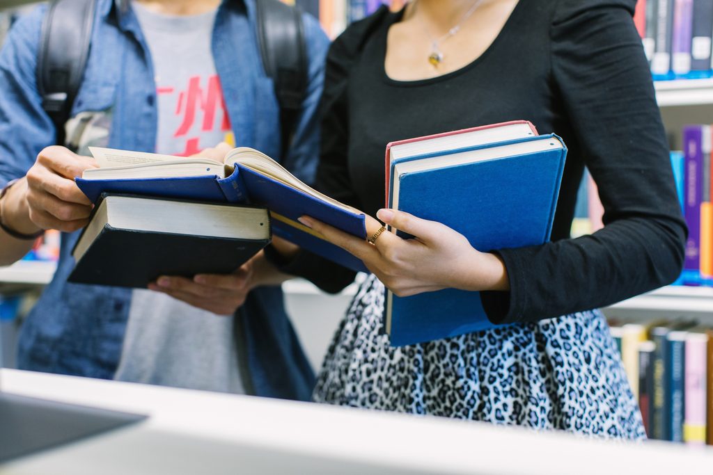 Students in library looking at books