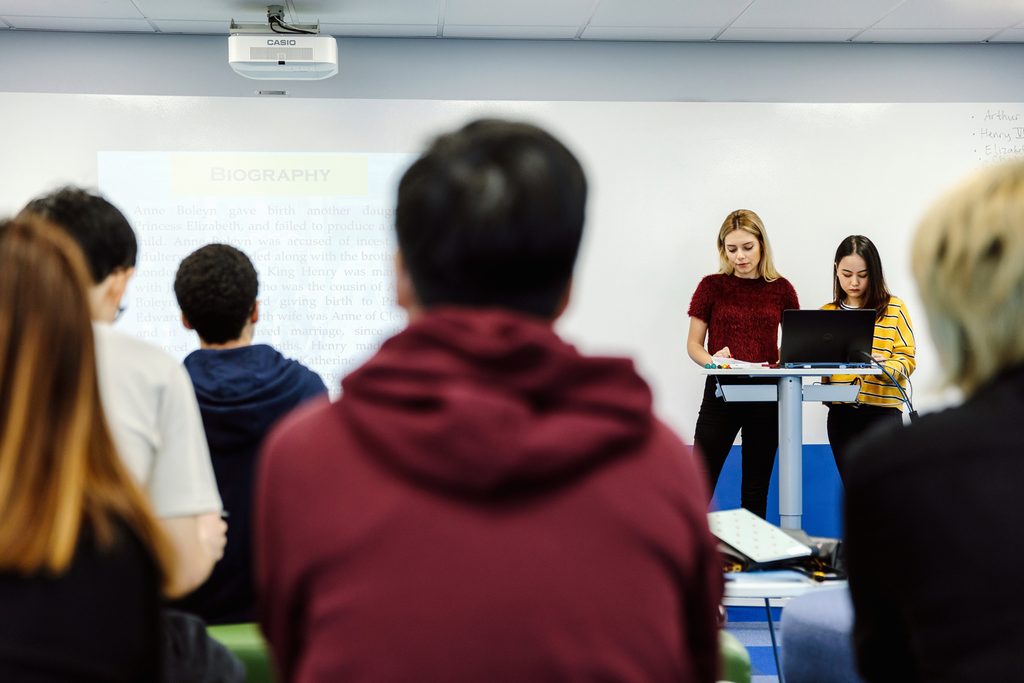 Students presenting assignment in classroom