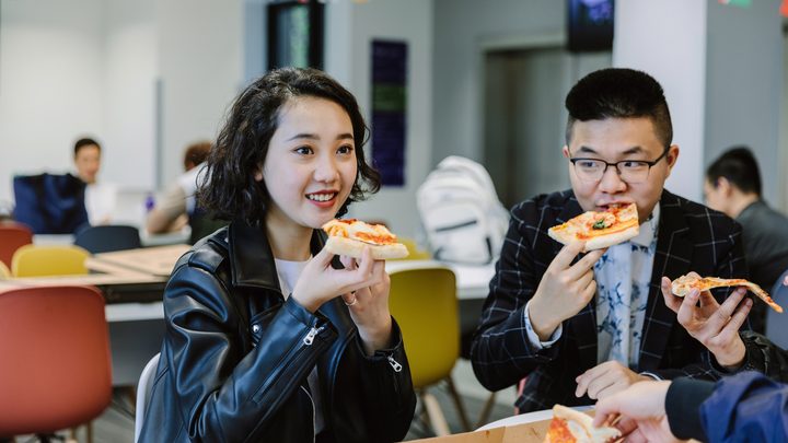 Student at KICL London eating pizza