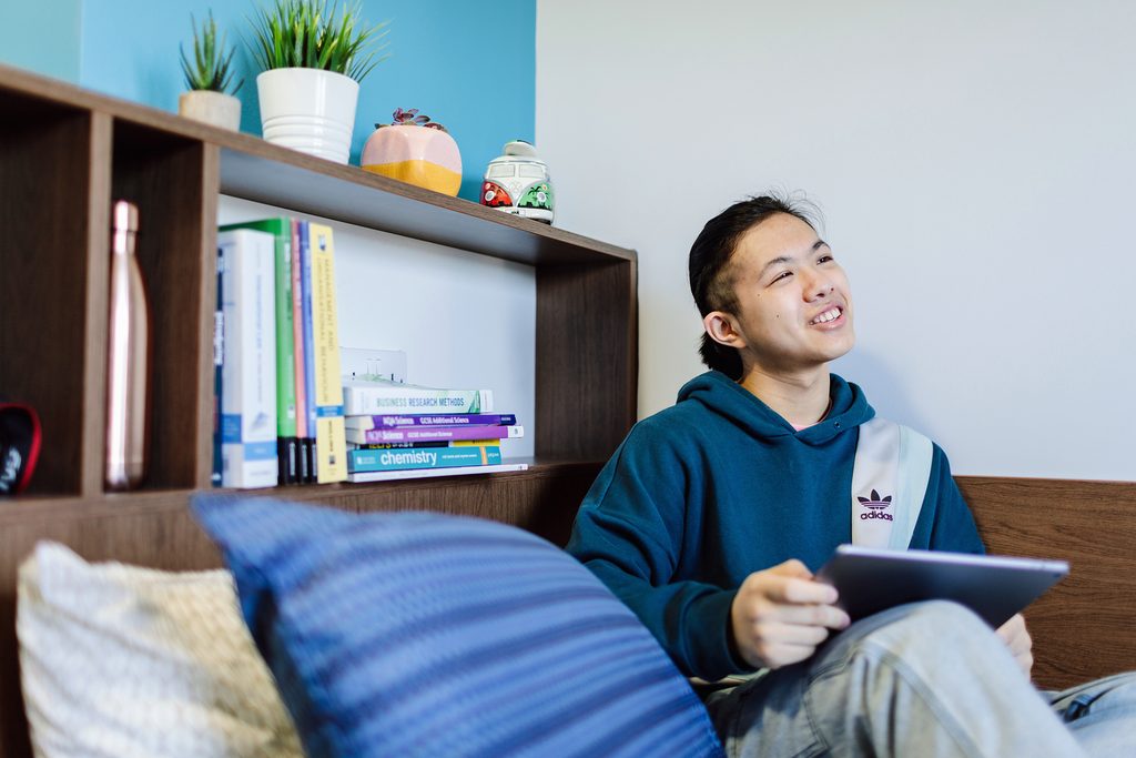 student in bedroom studying