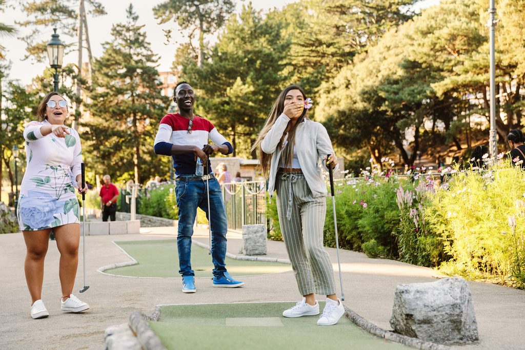 Three students playing mini golf in Bournemouth