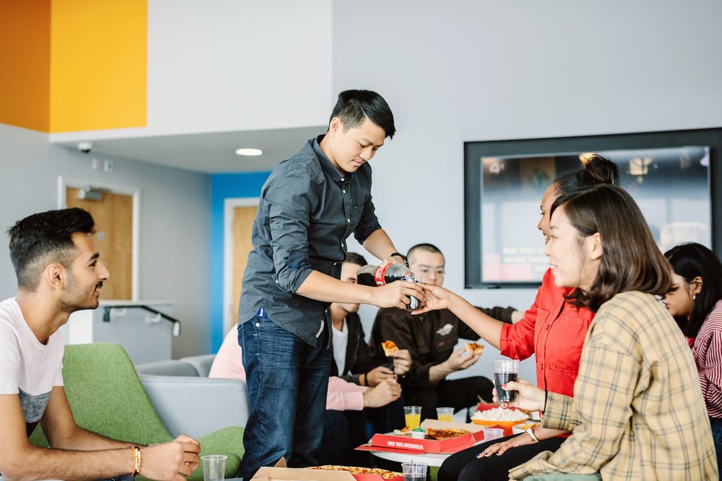 A group of students chatting and eating in a social space at the Kaplan Living Bournemouth