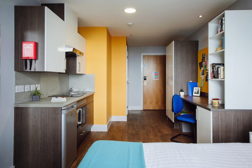A studio flat with bed, kitchenette and study desk at Kaplan Living Bournemouth