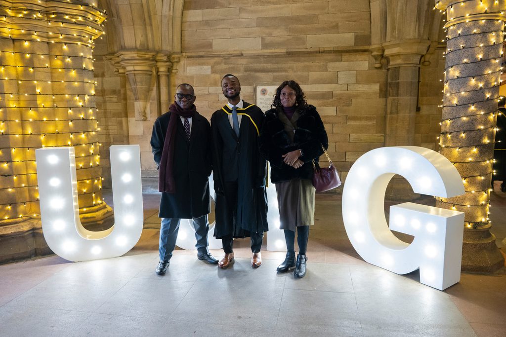 Student in a graduation ceremony with his parents