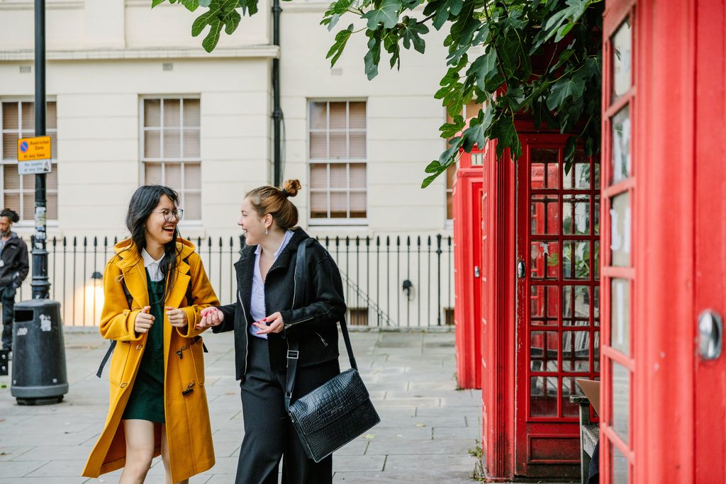 students walking in London near telephone boxes