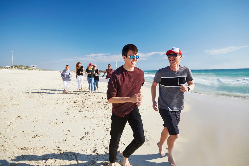 A pair of Murdoch University students walking on the beach
