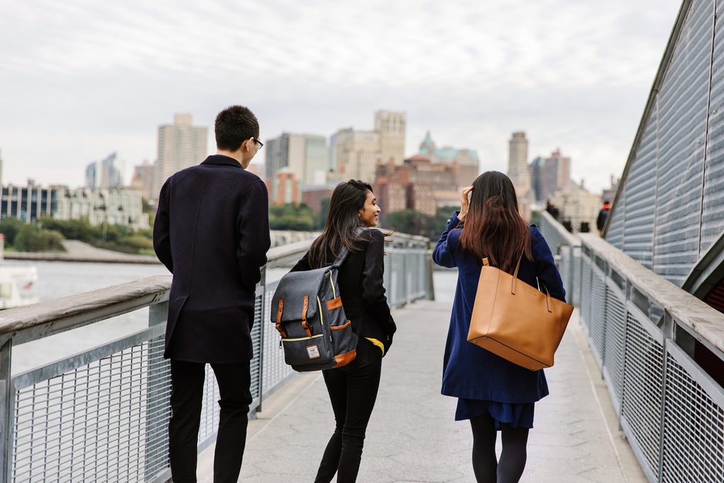 Three students crossing a bridge in New York City