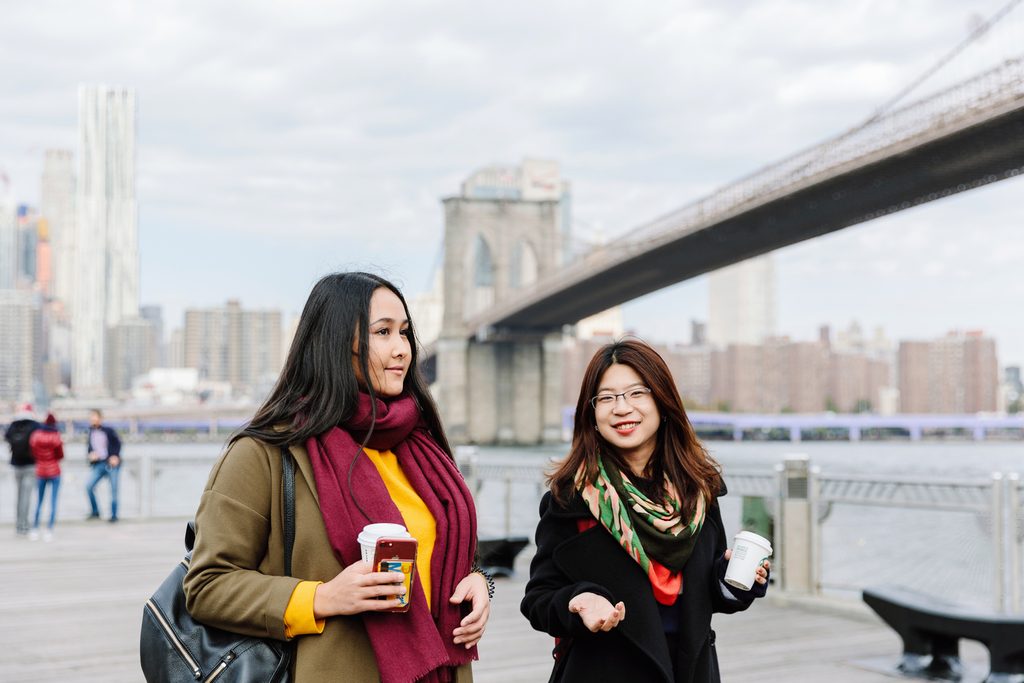 Two students walking near the river in New York City