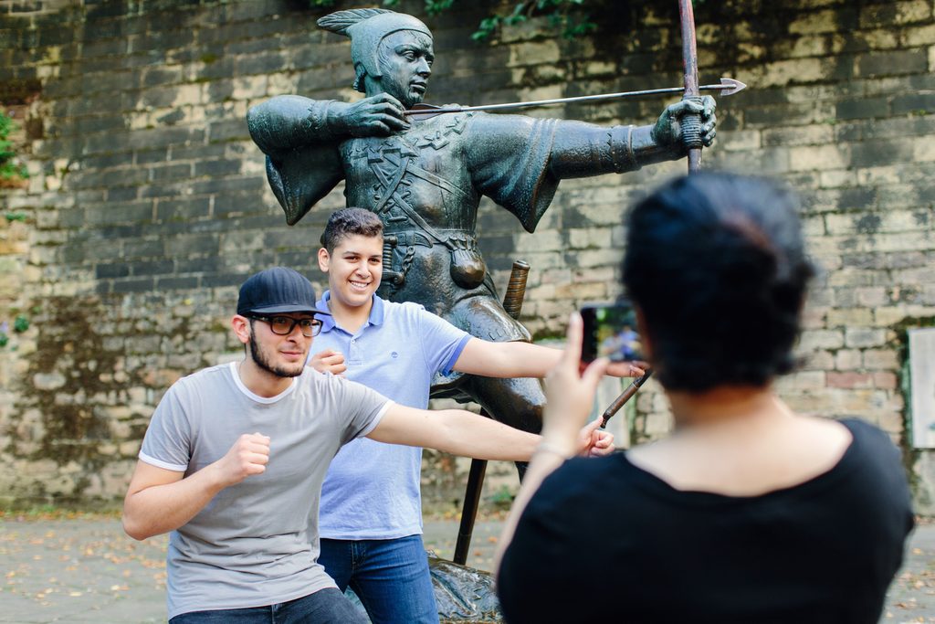 Students taking a picture in front of the Robin Hood Statue