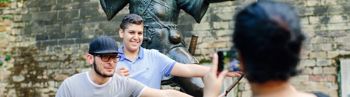 Students taking a picture in front of the Robin Hood Statue