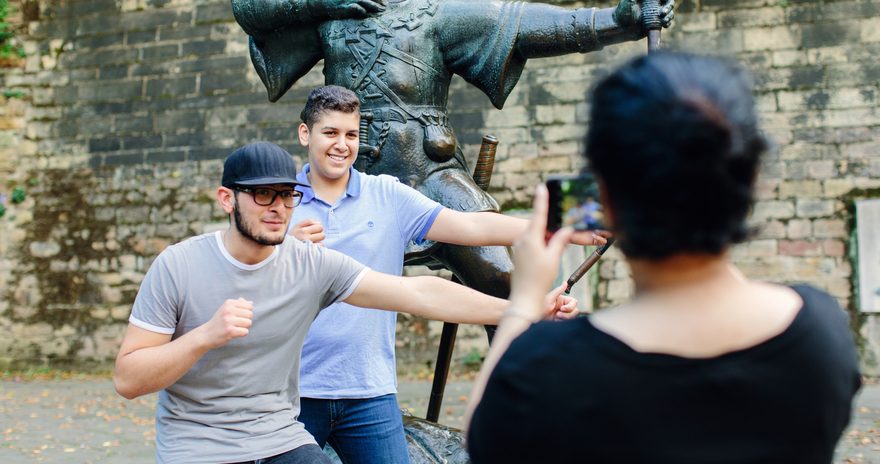 Students taking a picture in front of the Robin Hood Statue