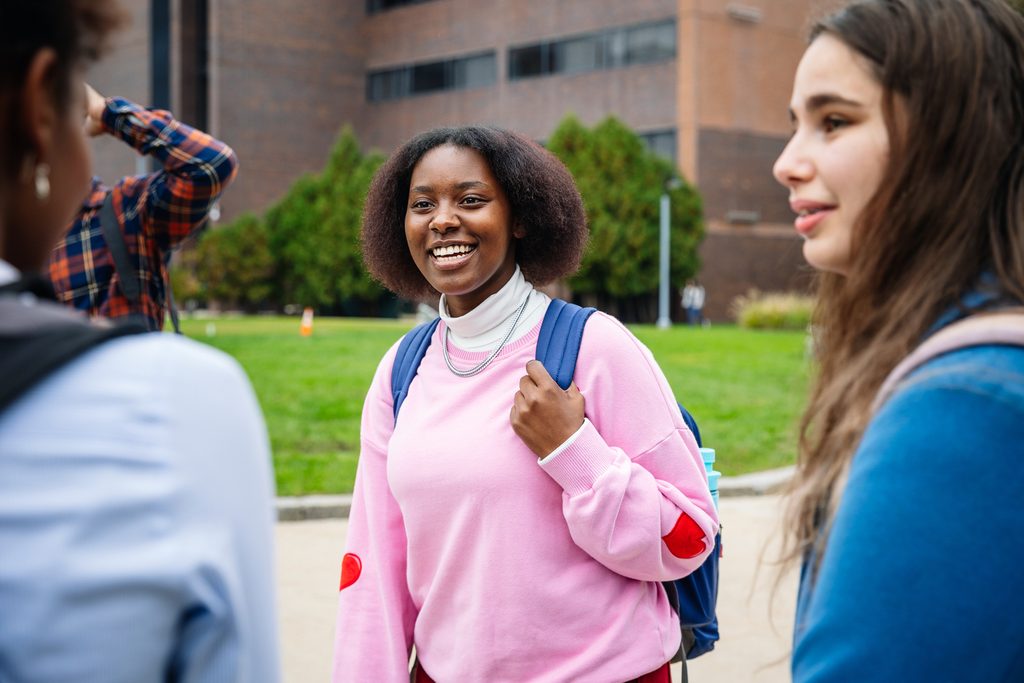 a group of students talking to each other in the campus