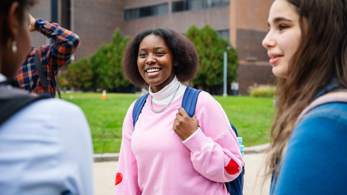 a group of students talking to each other in the campus