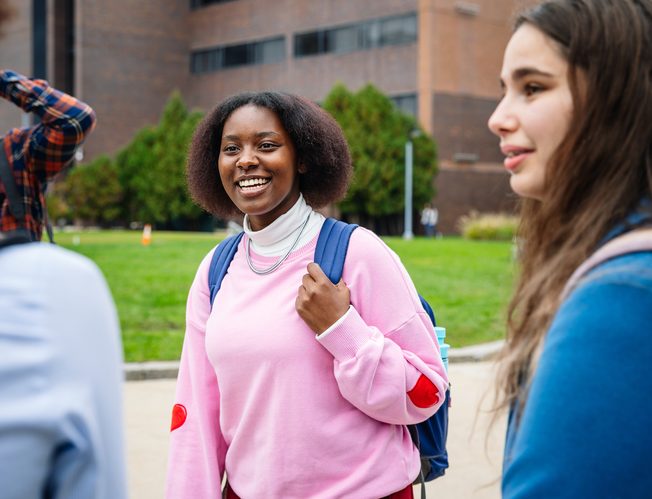 a group of students talking to each other in the campus