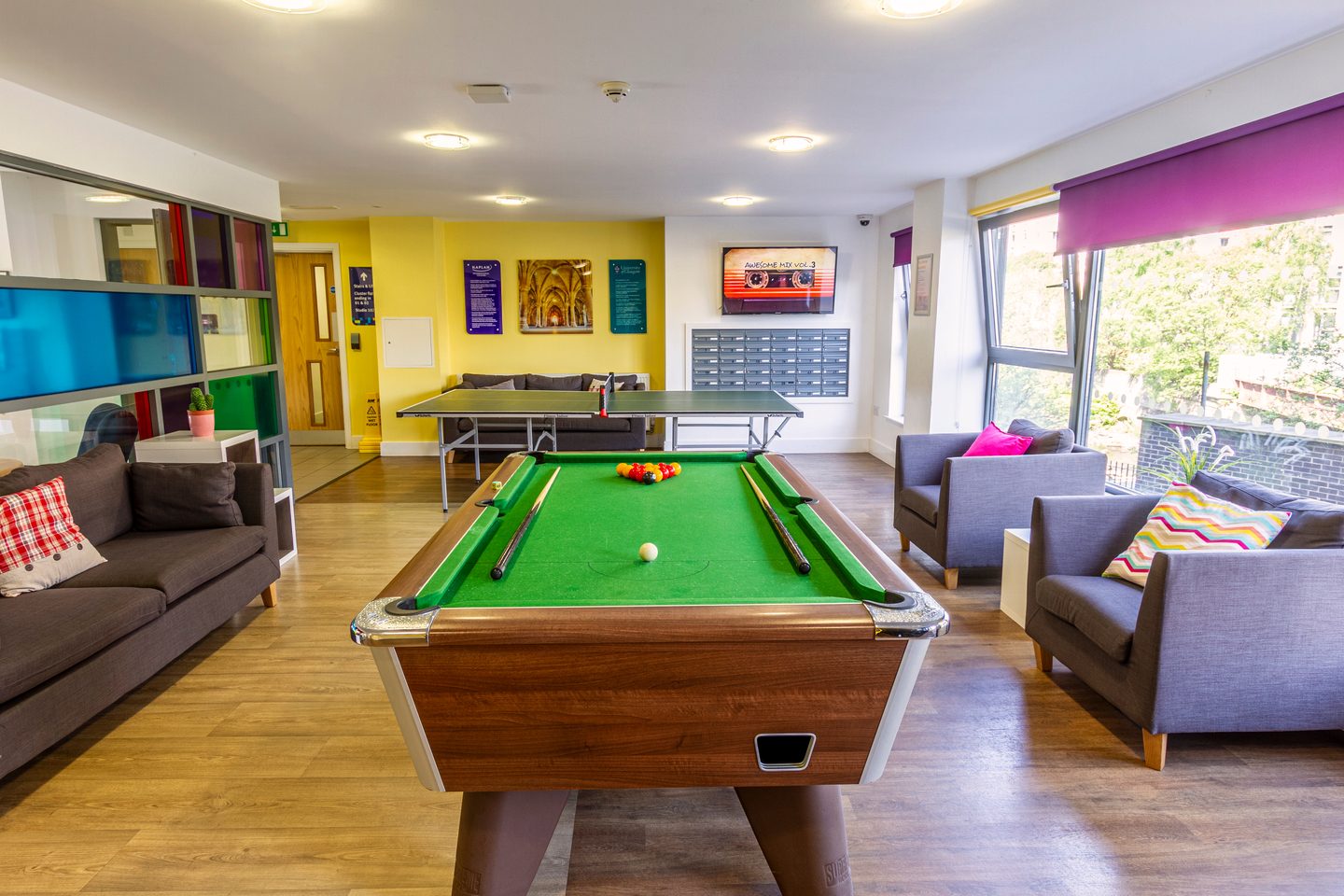 Game room with a pool table, a table tennis with a sofa and two armchairs