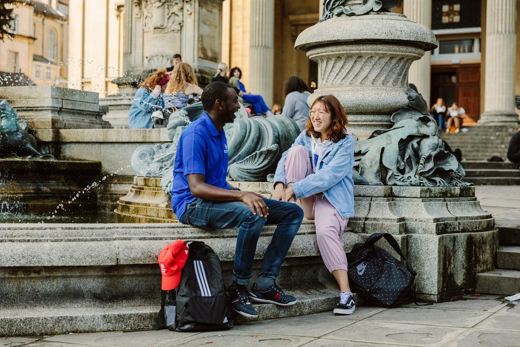 students sitting together and laughing in front of a fountain