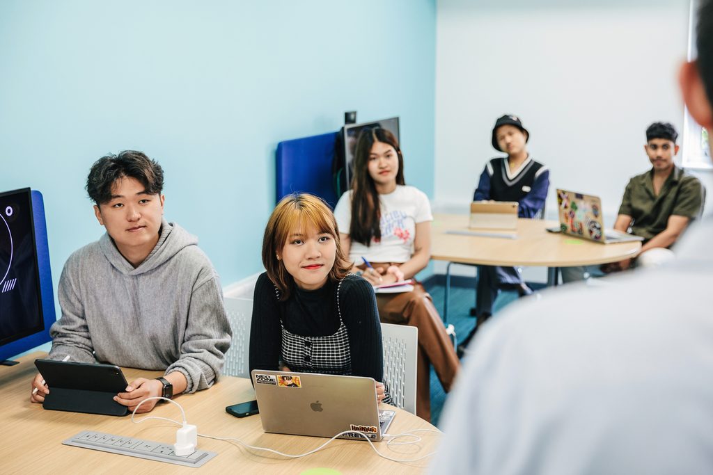 Students inside classroom listening to the teacher