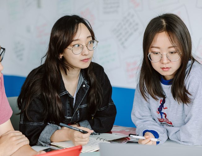 Group of three students with their notebooks in the classroom