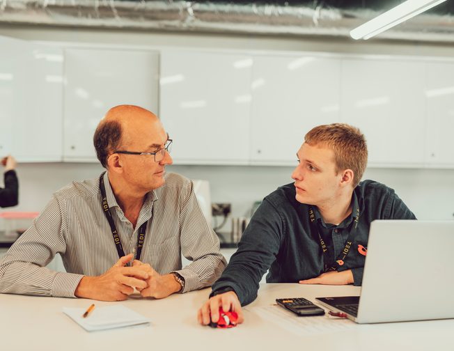 student and teacher at desk in classroom