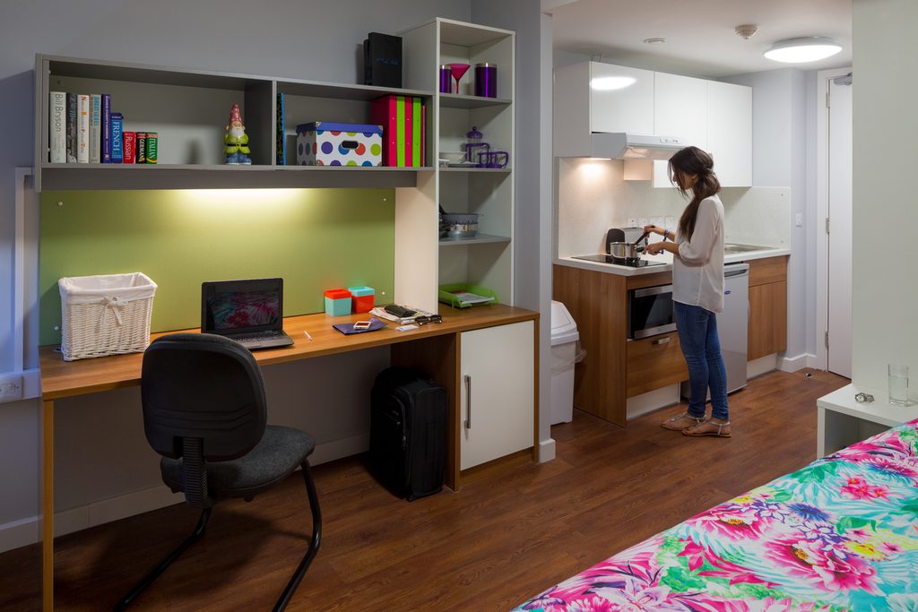 Student preparing meal in studio kitchenette