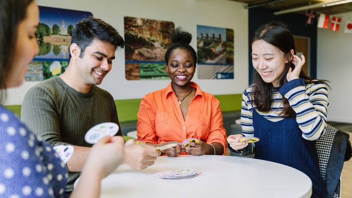 A group of students playing card game in shared area