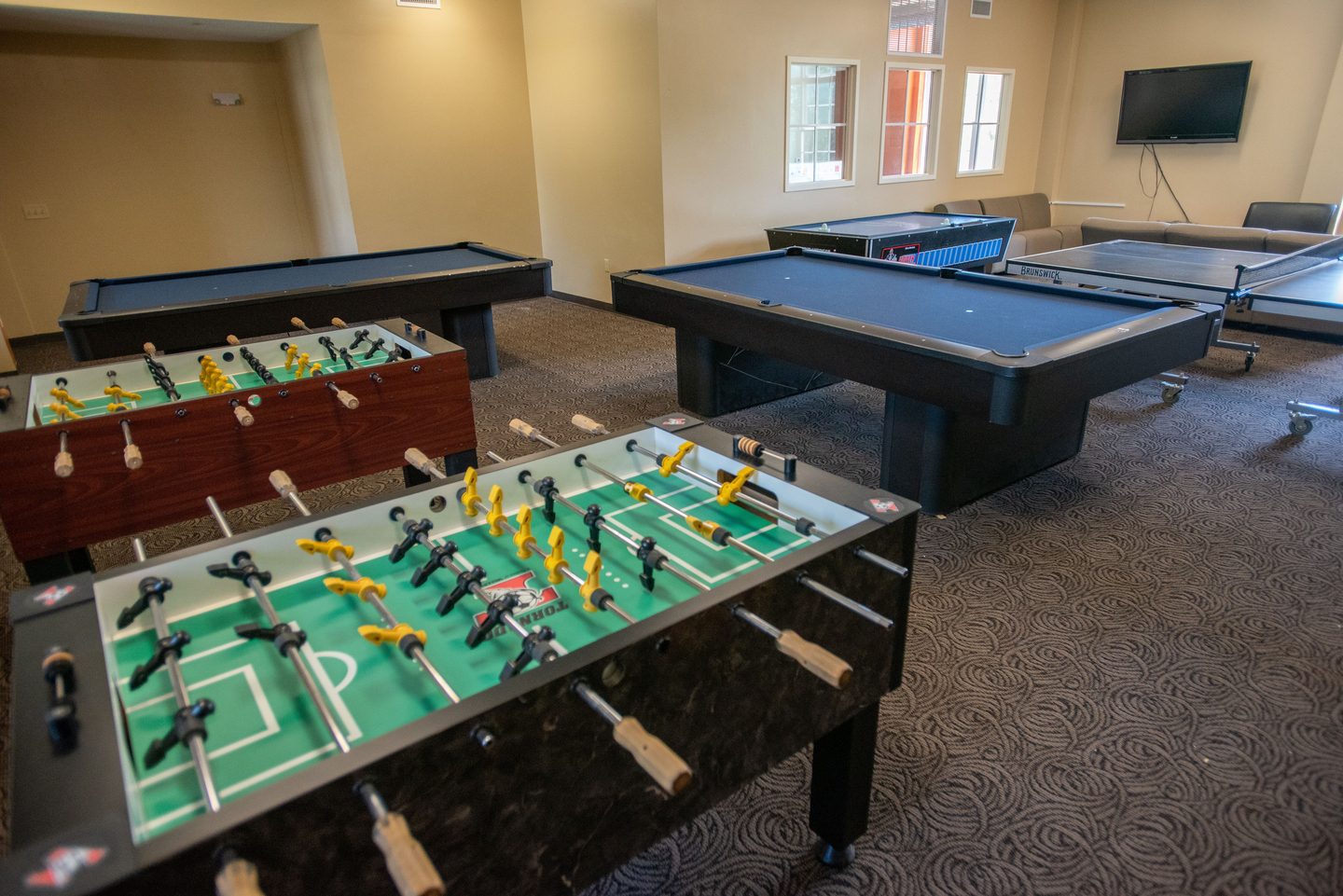 Residential Life game room with air hockey, foosball, and pool tables