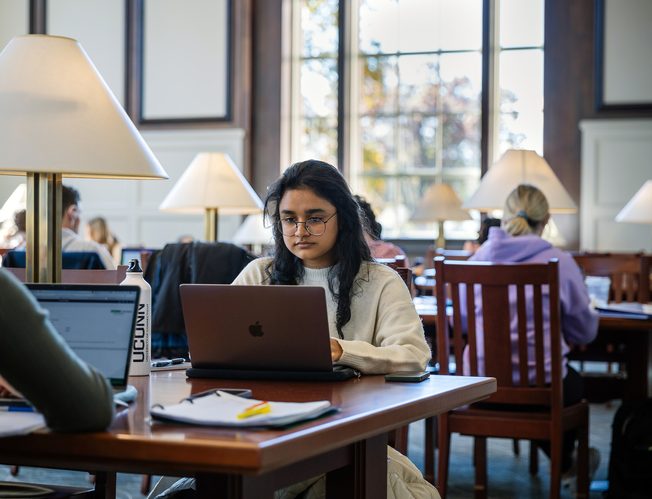 A student working on her laptop in UCONN library