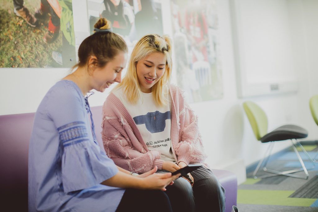 Two Essex International College students looking at a tablet