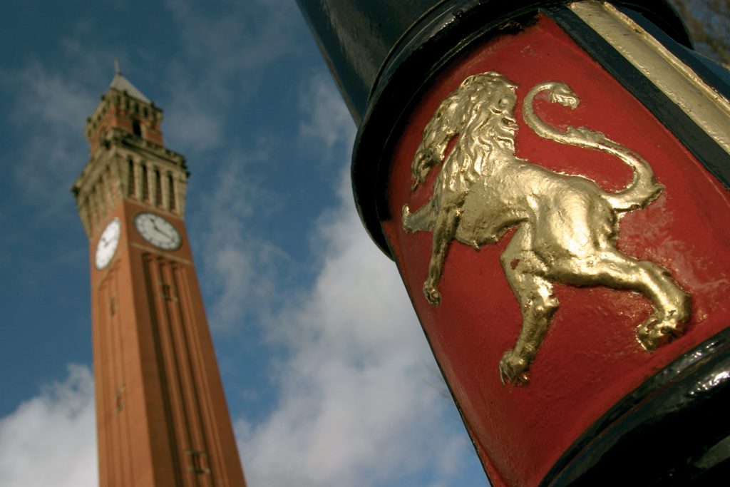University seal on lamppost with Old Joe Clock in the background