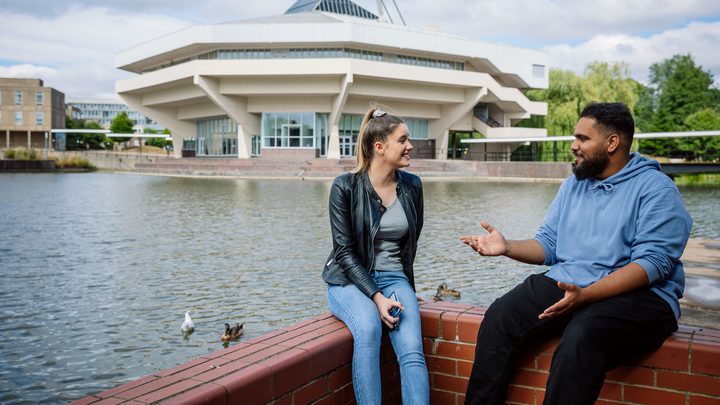 Students sitting at the riverside and having a chat