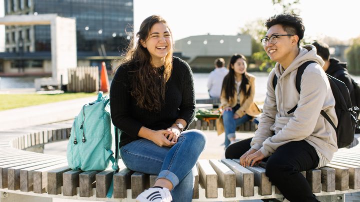 Students sitting on a bench and enjoying the nice weather