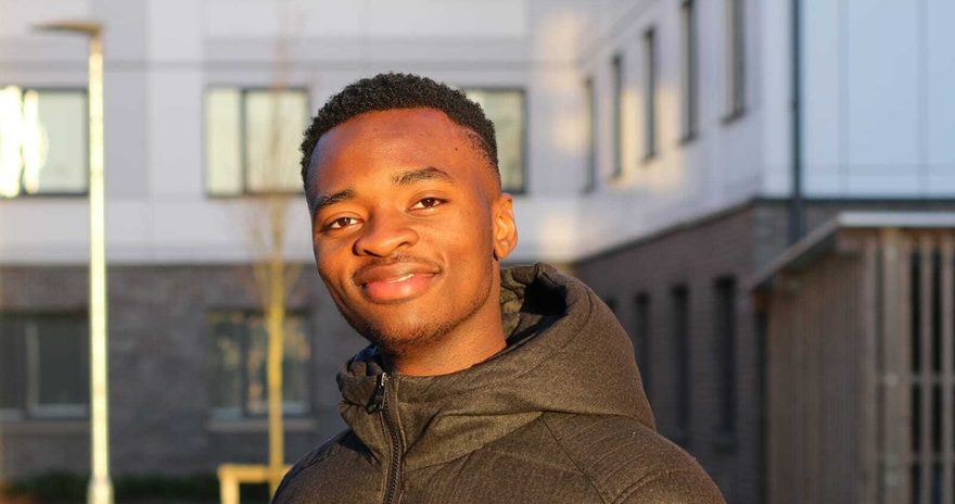 Kayode is posing for picture on campus