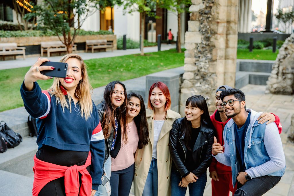Students using a phone to take a group selfie